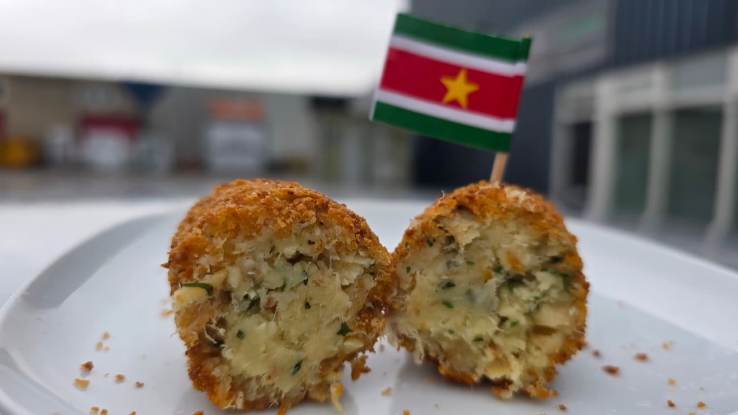 Surinaamse bakkeljauw kroket, doorgesneden met een Surinaamse vlag